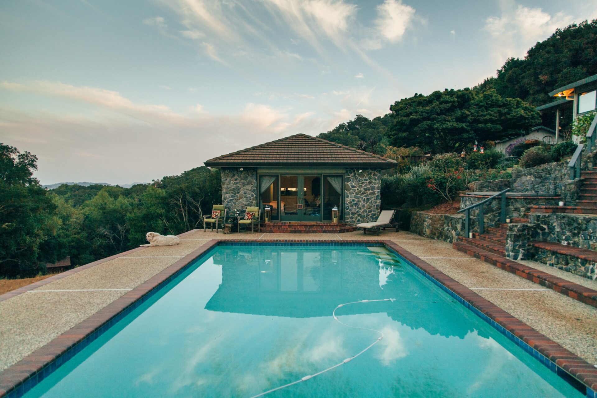 pool with trees and a stone building in the background