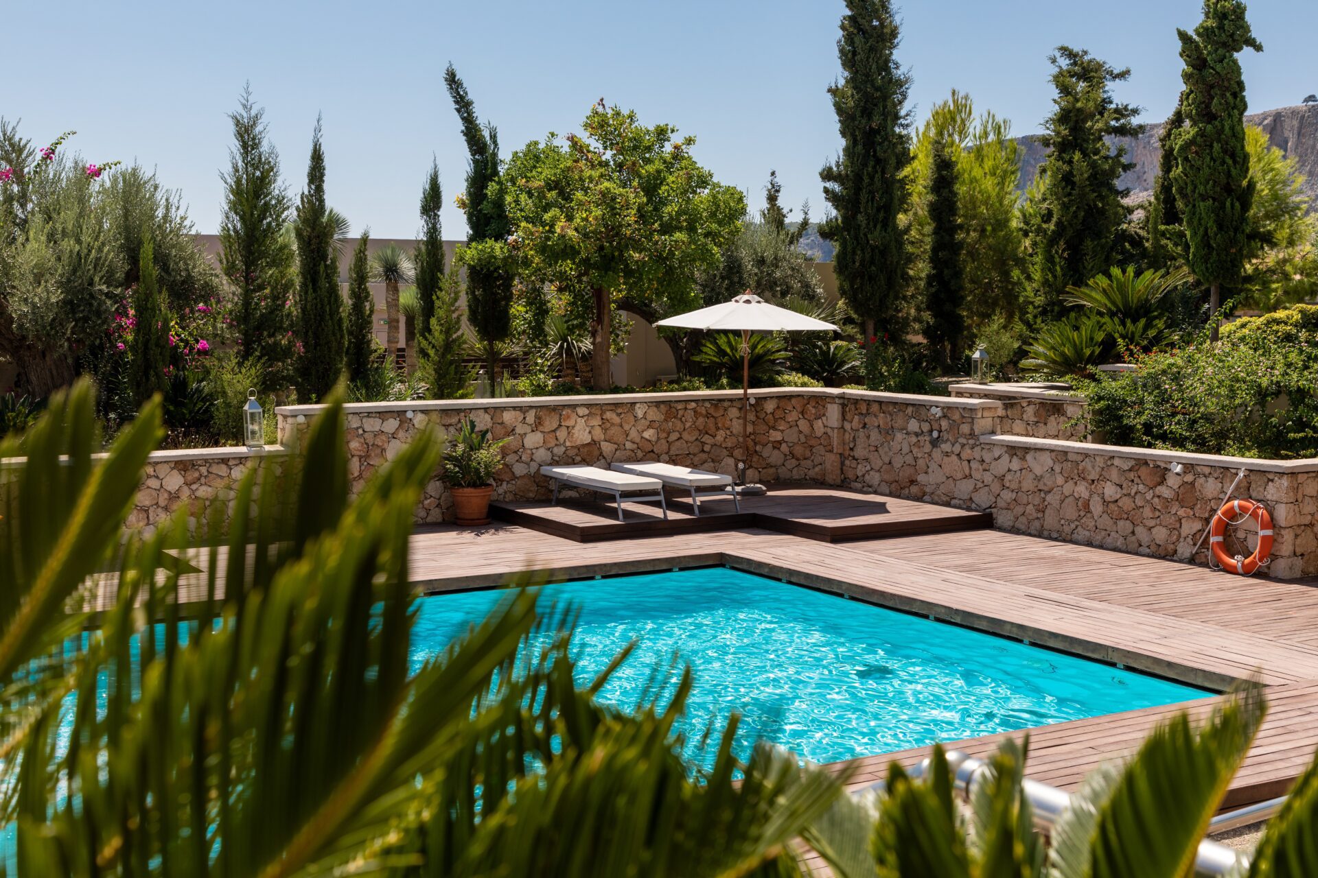 pool surrounded by stone wall and trees